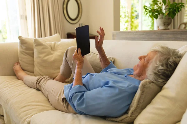 Mulher Caucasiana Sênior Deitada Sofá Usando Tablet Retiro Aposentadoria Conceito — Fotografia de Stock