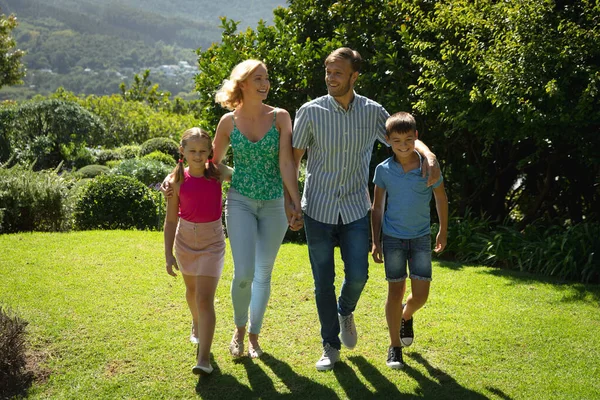 娘と息子の屋外で幸せな白人のカップルは 日当たりの良い庭を歩いてください 家族みんなで自由な時間を楽しむ — ストック写真