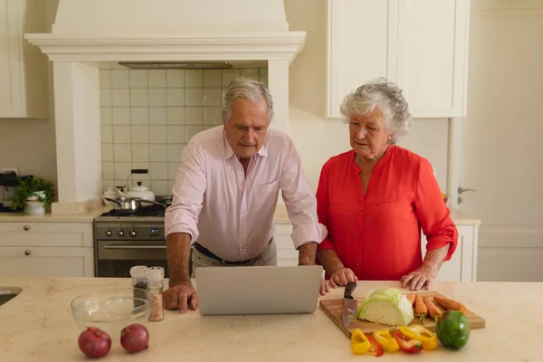 Senior Pareja Caucásica Cocinar Juntos Uso Ordenador Portátil Cocina Retiro —  Fotos de Stock