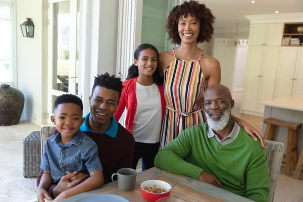 朝食中にテーブルに座って笑顔アフリカ系アメリカ人の複数世代の家族の肖像画 家族みんなで自由な時間を楽しむ — ストック写真