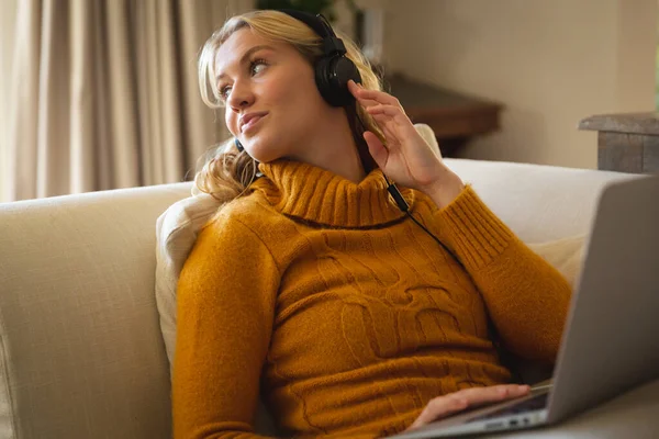 Mujer Caucásica Sonriente Relajarse Sofá Sala Estar Con Auriculares Uso —  Fotos de Stock