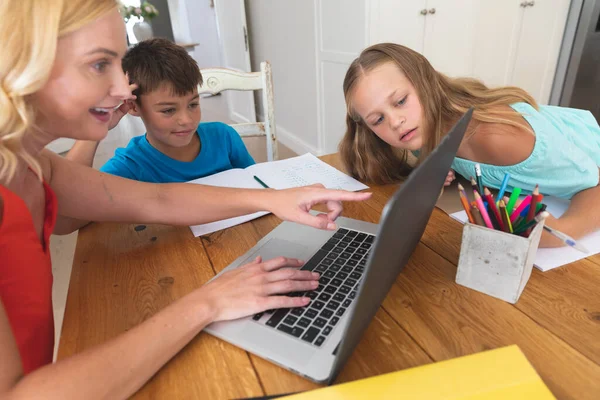 白种人的母亲使用笔记本电脑 与女儿和儿子一起在家里做作业 家庭生活 在家里一起学习 — 图库照片