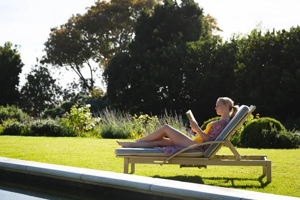Usmívající Běloška Odpočívající Lehátku Krásném Slunném Zahradním Čtení Knihy Trávit — Stock fotografie