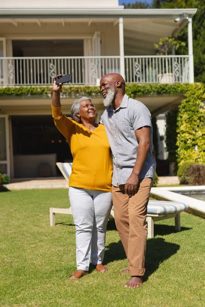 Pareja Afroamericana Mayor Pasando Tiempo Soleado Jardín Juntos Tomando Selfies —  Fotos de Stock