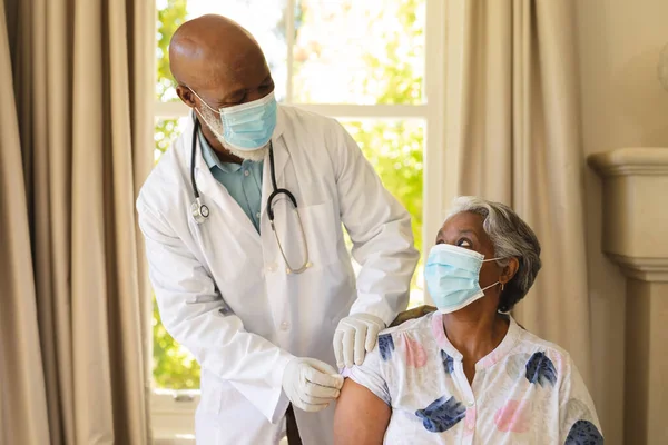 Senior African American Woman Male Doctor Face Masks Woman Receiving — Stock Photo, Image