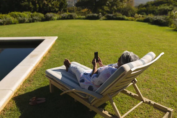 Senior Afrikansk Amerikansk Kvinna Använder Smartphone Solstol Vid Poolen Solig — Stockfoto