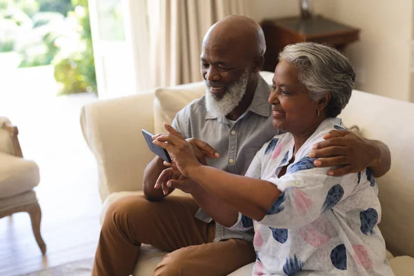 Senior Afrikaans Amerikaanse Paar Zit Bank Met Behulp Van Smartphone — Stockfoto