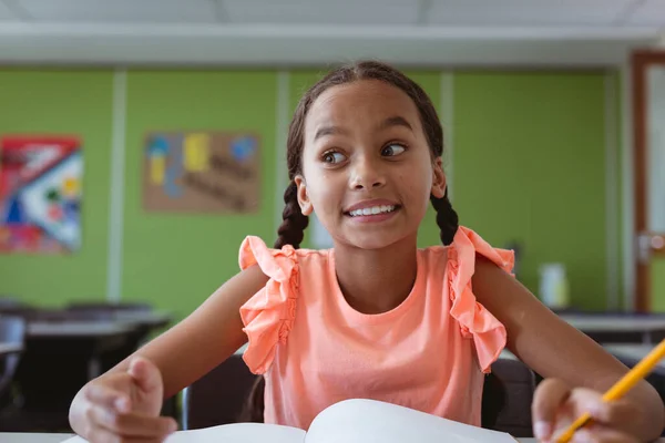 Portret Van Een Lachend Gemengd Schoolmeisje Aan Een Bureau Klas — Stockfoto