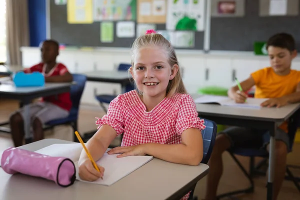Retrato Menina Caucasiana Sorrindo Enquanto Senta Sua Mesa Classe Escola — Fotografia de Stock