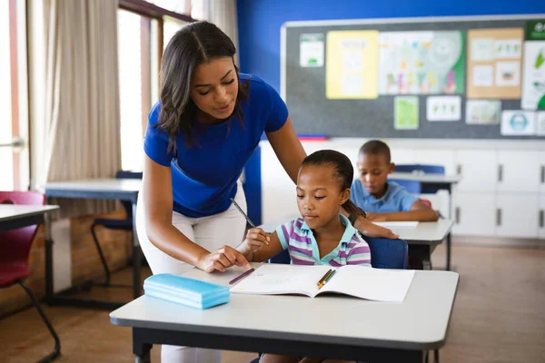 在小学课堂上任教非洲裔美国女孩的非裔美国女教师 学校和教育概念 — 图库照片