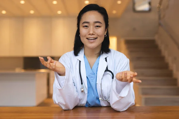Porträtt Asiatisk Kvinnlig Läkare Sitter Vid Skrivbordet Och Pratar Videokonsultation — Stockfoto