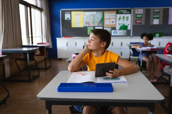 Niño Caucásico Sosteniendo Tableta Digital Mientras Está Sentado Escritorio Clase — Foto de Stock