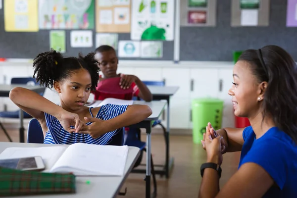 アフリカ系アメリカ人の女性教師と 小学校で手話で話す少女 学校や教育の概念 — ストック写真