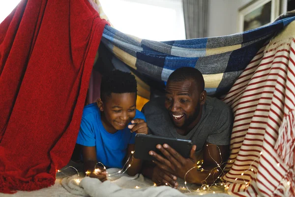 Ευτυχισμένος Αφροαμερικάνος Πατέρας Και Γιος Ξαπλωμένοι Κουβερτούλα Χρησιμοποιώντας Τάμπλετ Οικογενειακή — Φωτογραφία Αρχείου