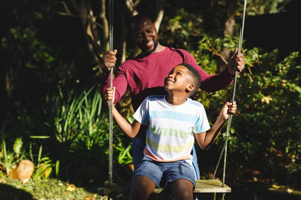 Afro Americano Padre Con Hijo Divirtiéndose Jugando Swing Jardín Familia —  Fotos de Stock