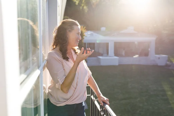 Feliz Mujer Caucásica Mayor Hablando Teléfono Inteligente Pie Balcón Soleado —  Fotos de Stock