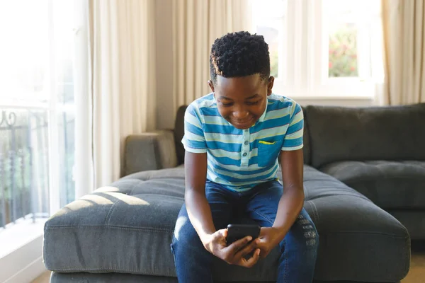 African American Boy Using Smartphone Sitting Couch Sunny Living Room — Stock Photo, Image