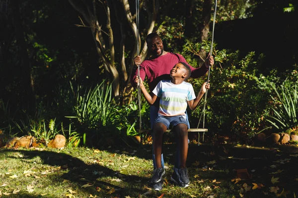 Afro Americano Padre Con Hijo Divirtiéndose Jugando Swing Jardín Familia —  Fotos de Stock