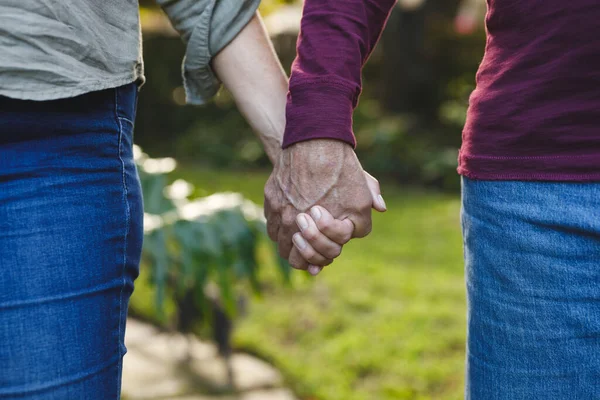 两对高年级的高加索夫妇牵着手在花园里散步 退休生活方式 呆在家里 — 图库照片