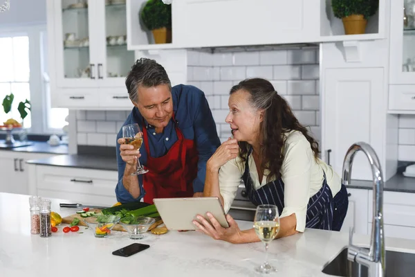 在现代厨房里快乐的老夫妇 一起做饭 用平板电脑 退休生活方式 呆在家里 — 图库照片