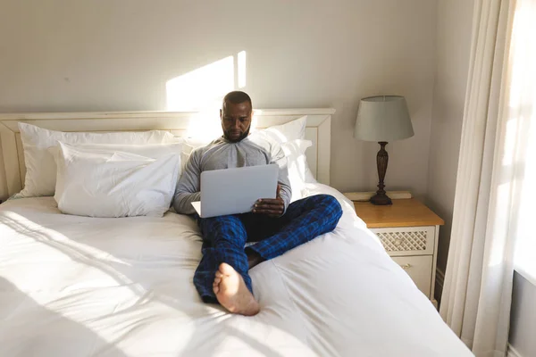 Afro Amerikaanse Man Met Laptop Liggend Bed Zijn Slaapkamer Tijd — Stockfoto