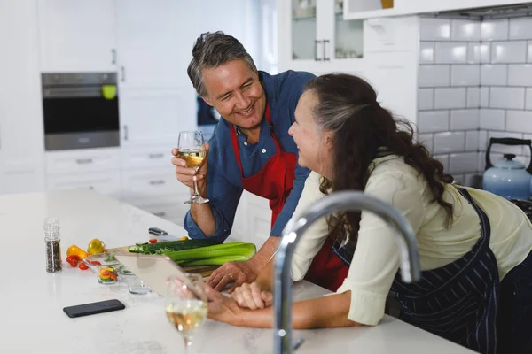 Feliz Pareja Ancianos Caucásicos Cocina Cocinar Juntos Beber Vino Utilizando —  Fotos de Stock