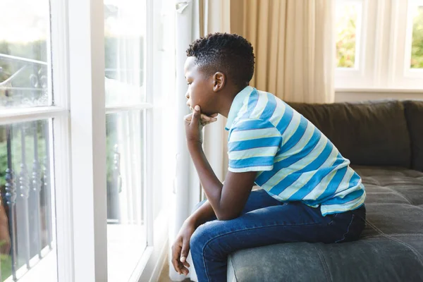 Ragazzo Afroamericano Premuroso Seduto Guardare Fuori Dalla Finestra Soggiorno Passare — Foto Stock