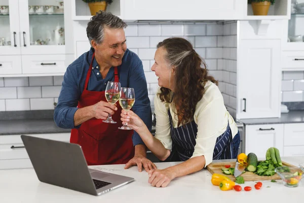 Feliz Pareja Ancianos Caucásicos Cocina Cocinar Juntos Beber Vino Utilizando —  Fotos de Stock