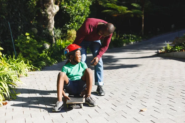 Pai Afro Americano Com Filho Sorrindo Brincando Com Skate Jardim — Fotografia de Stock