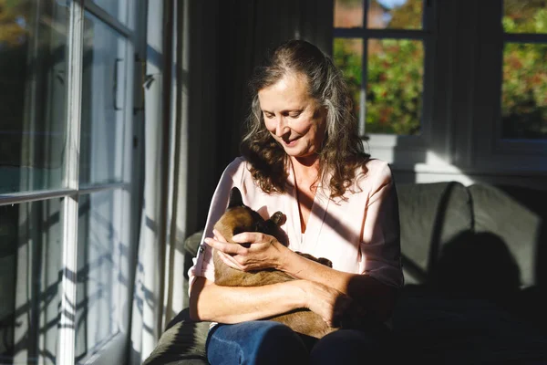 ベッドルームでペットの猫を抱えている幸せなシニア白人女性 家で一人で過ごす退職生活や — ストック写真