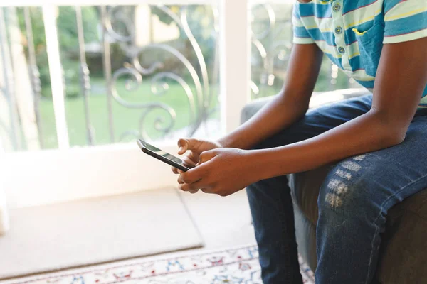 Middel Afrikansk Amerikansk Pojke Som Använder Smartphone Och Sitter Soffan — Stockfoto