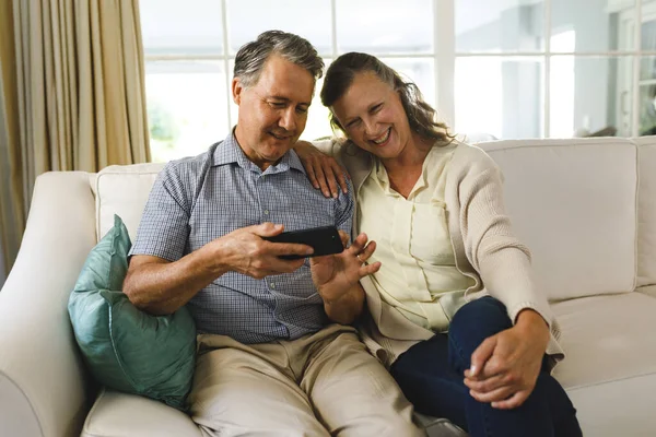 Feliz Pareja Ancianos Caucásicos Sala Estar Sentado Sofá Utilizando Teléfono —  Fotos de Stock