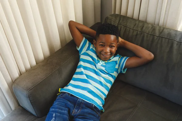 Retrato Rapaz Afro Americano Sorridente Deitado Sofá Sala Estar Passar — Fotografia de Stock