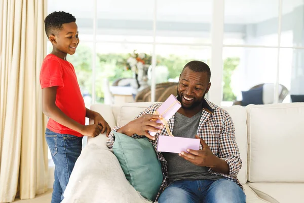 Africký Americký Otec Otevírá Dárek Svého Syna Usmívá Obýváku Rodina — Stock fotografie