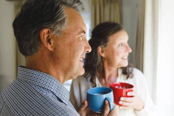 Feliz Pareja Ancianos Caucásicos Pie Junto Ventana Sosteniendo Copas Estilo — Foto de Stock