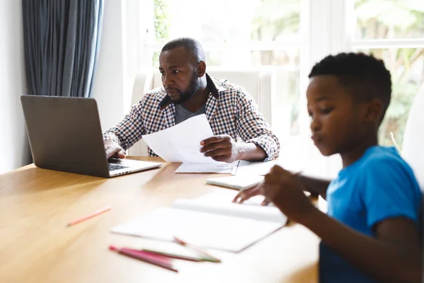 Der Afroamerikanische Vater Arbeitet Esszimmer Laptop Während Sein Sohn Mit — Stockfoto