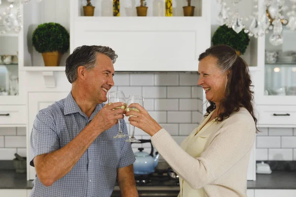 モダンなキッチンで幸せな高齢者の白人カップル ワインを飲み トーストを作り 引退後の生活や家で過ごす時間 — ストック写真