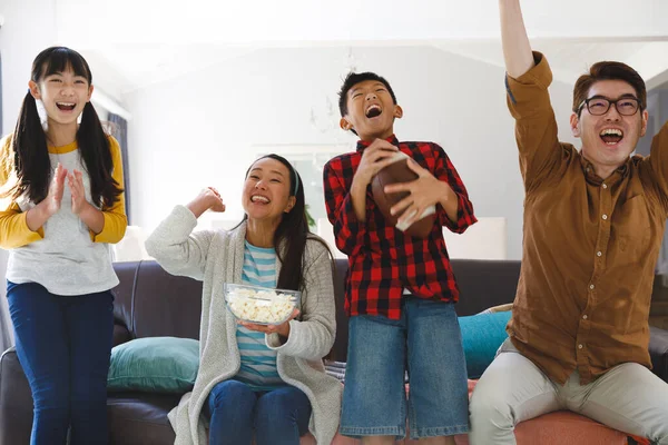 亚洲父母带着儿子和女儿坐在沙发上 用爆米花看电视 家庭娱乐和在家的闲暇时间 — 图库照片