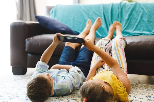 Beyaz Erkek Kız Kardeşler Tablet Kullanarak Oturma Odasında Yerde Yatıyorlar — Stok fotoğraf