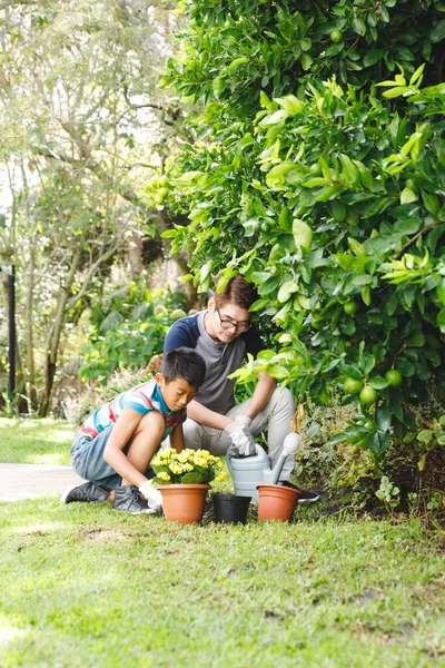 幸せなアジアの父と息子は笑顔で 手袋を着用し 庭に植物を植えます 家庭菜園での余暇 — ストック写真