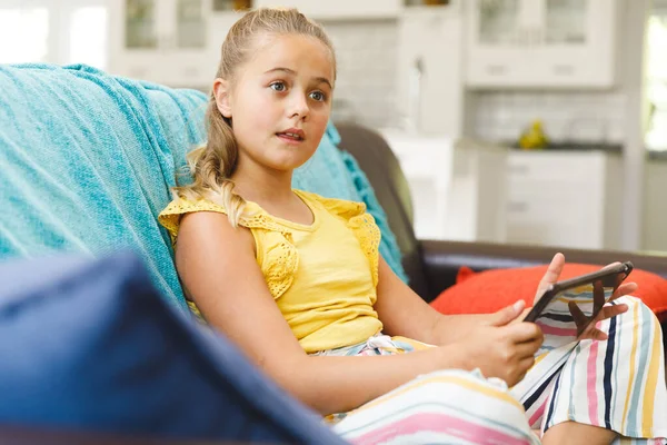 Blank Meisje Zit Bank Gebruikt Een Tablet Woonkamer Kindervrije Tijd — Stockfoto