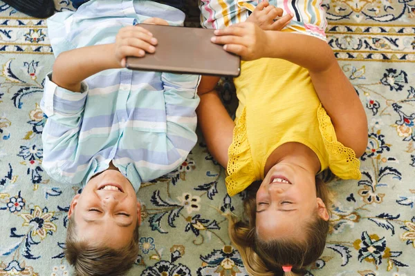 Smiling Caucasian Brother Sister Lying Living Room Using Tablet Childhood — Stock Photo, Image