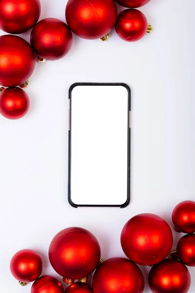 白い背景にコピースペースと赤い泡とスマートフォンの構成 クリスマス お祝いのコンセプト — ストック写真