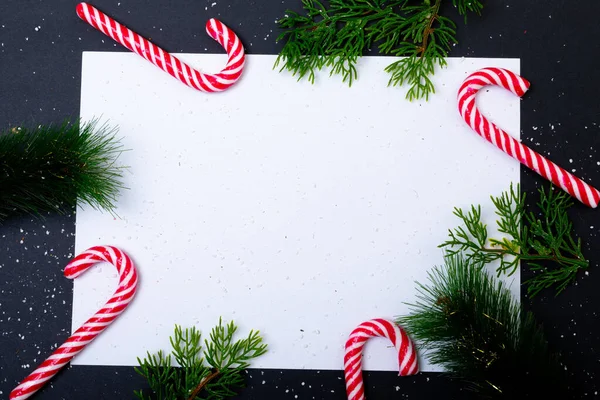 黒の背景に木の枝やキャンディーの杖で囲まれたコピースペースを持つカードの構成 クリスマス お祝いのコンセプト — ストック写真
