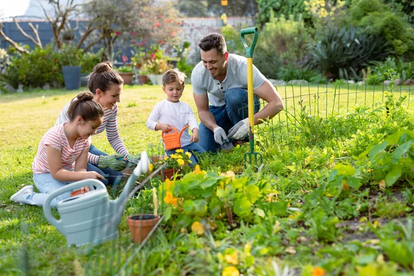 幸せな白人の家族の園芸と散水植物を一緒に 家族で家や庭で楽しみながら — ストック写真