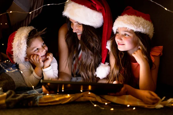 Happy Caucasian Mother Daughter Son Wearing Santa Hats Using Tablet — Stock Photo, Image