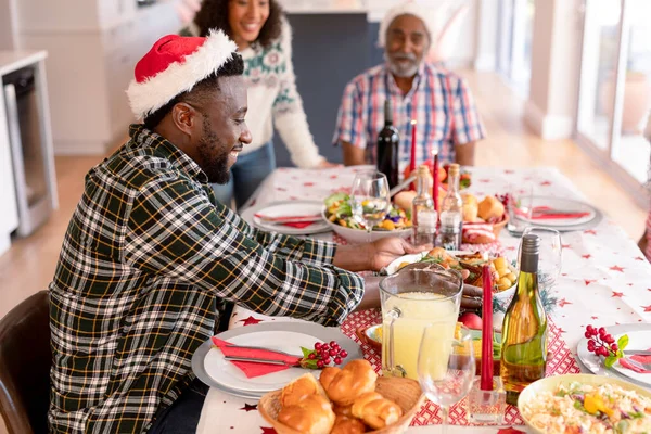 Família Multi Geração Feliz Vestindo Chapéus Papai Noel Tendo Refeição — Fotografia de Stock