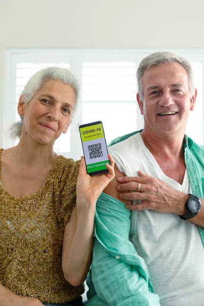 Sonriente Pareja Ancianos Caucásicos Mostrando Teléfono Inteligente Con Pasaporte Vacuna —  Fotos de Stock