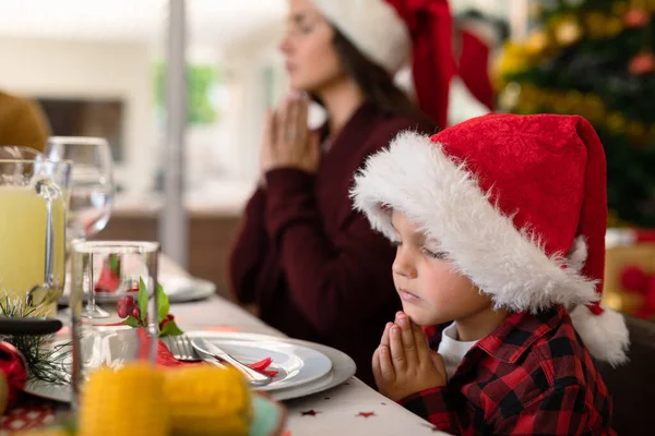 白人の少年と彼の母親はクリスマスのテーブルで一緒に祈っています クリスマスの時間と祭りを一緒に家で — ストック写真