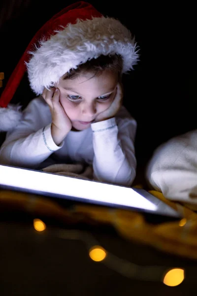 Focused Caucasian Boy Wearing Santa Hat Using Tablet Christmas Time — Stock Photo, Image